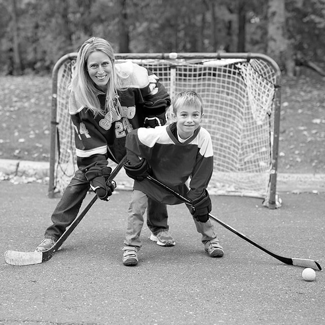 Mom and son playing street hockey